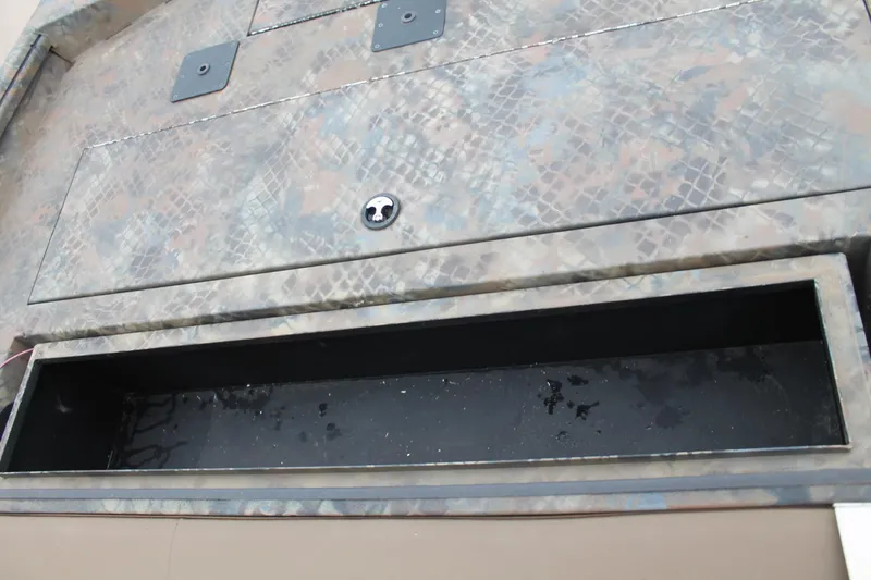 Slide: The Image of 2023 Excel Catfish Pro 21 Side Console storage compartment with camouflage pattern. - 13