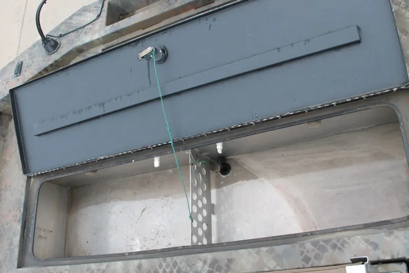 Slide: The Image of 2023 Excel Catfish Pro 21 Side Console storage compartment, open and empty. - 14