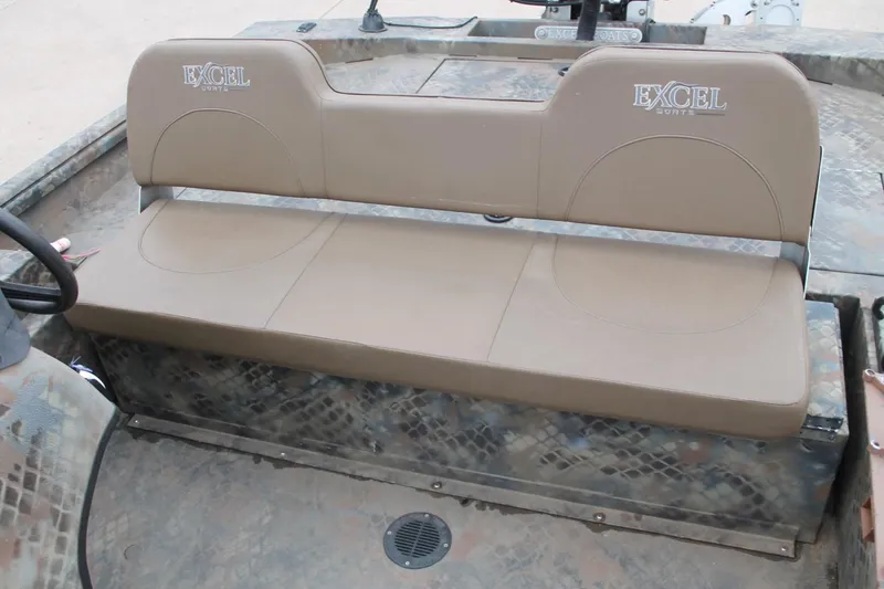 Slide: The Image of 2023 Excel Catfish Pro 21 Side Console boat seat, tan upholstery, camo-patterned flooring. - 23