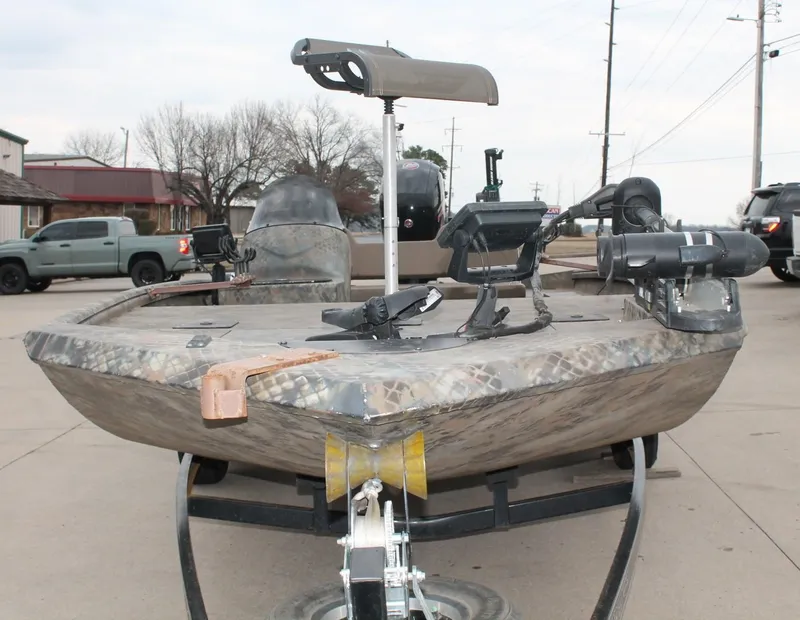 Slide: The Image of 2023 Excel Catfish Pro 21 Side Console boat on trailer, camo design, outdoor setting. - 4