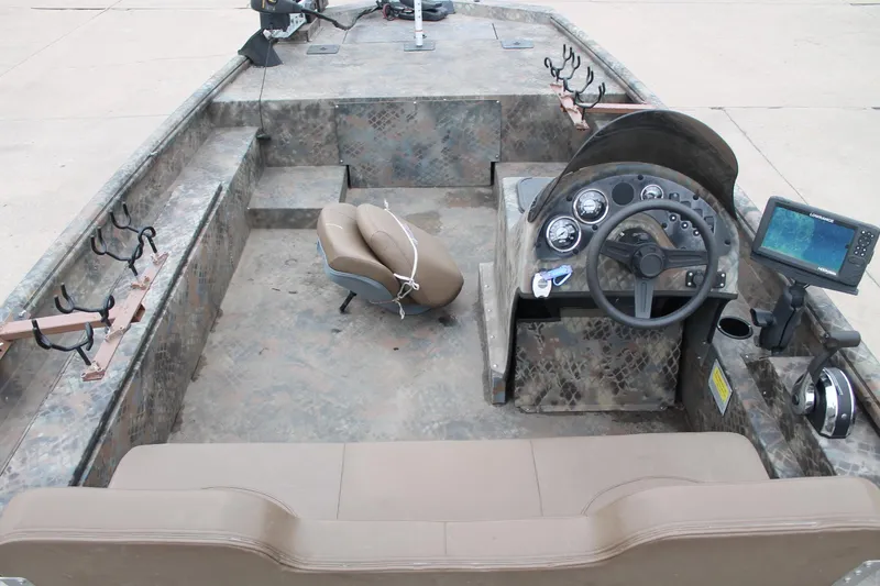 Slide: The Image of 2023 Excel Catfish Pro 21 Side Console boat interior with steering wheel and fishing rod holders. - 7