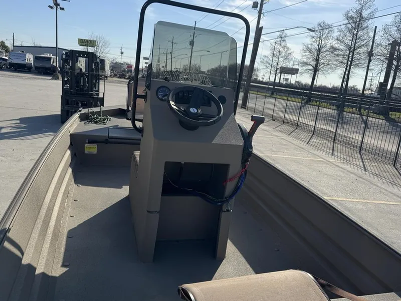 Slide: The Image of 2024 Alweld 1752 Marsh boat interior with steering console, parked outdoors. - 14