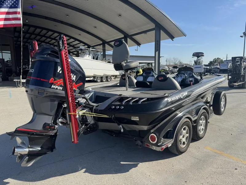 Slide: The Image of 2007 Ranger Z21 Comanche boat with Yamaha engine, parked outdoors under a canopy. - 13
