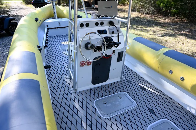 Slide: The Image of 2007 Ribcraft 9.0 boat interior with steering console and yellow seating. - 11
