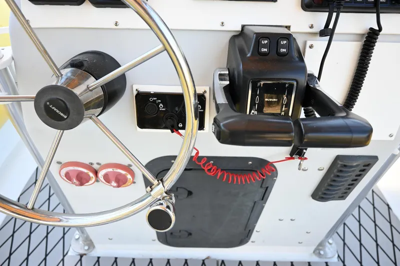 Slide: The Image of Control panel of a 2007 Ribcraft 9.0 boat with steering wheel and throttle controls. - 17