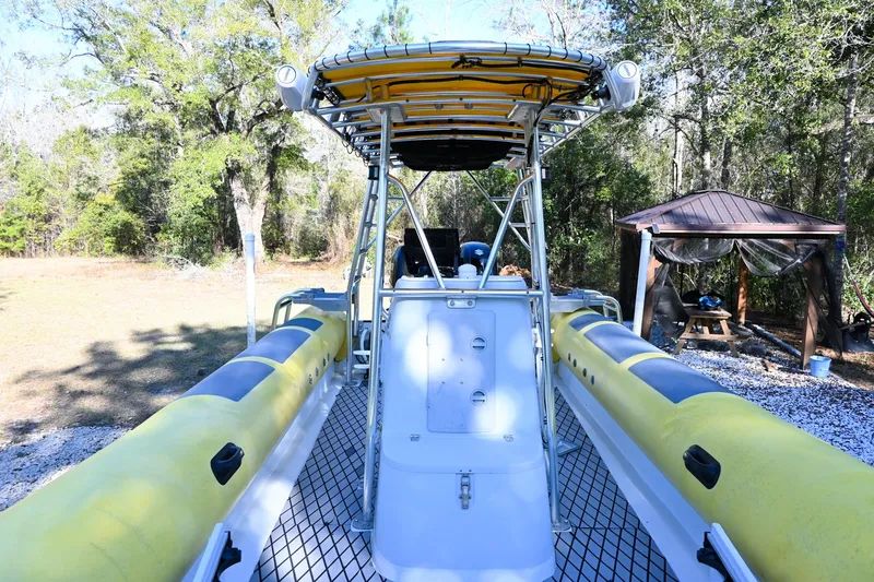 Slide: The Image of 2007 Ribcraft 9.0 boat with yellow inflatable sides, parked outdoors. - 21