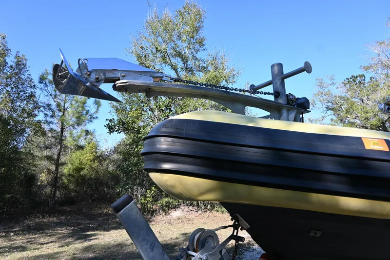 Slide: The Image of 2007 Ribcraft 9.0 boat with anchor, outdoors, surrounded by trees. - 27
