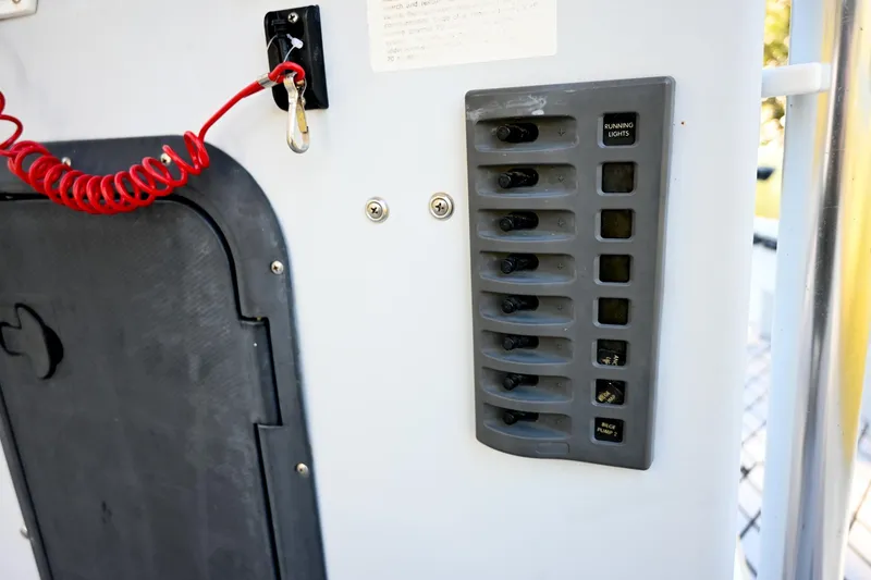 Slide: The Image of Control panel on a 2007 Ribcraft 9.0 boat with switches and safety cord. - 32