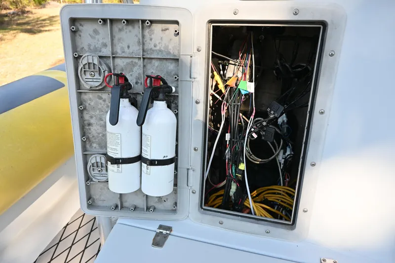 Slide: The Image of Electrical compartment with fire extinguishers on a 2007 Ribcraft 9.0 boat. - 35