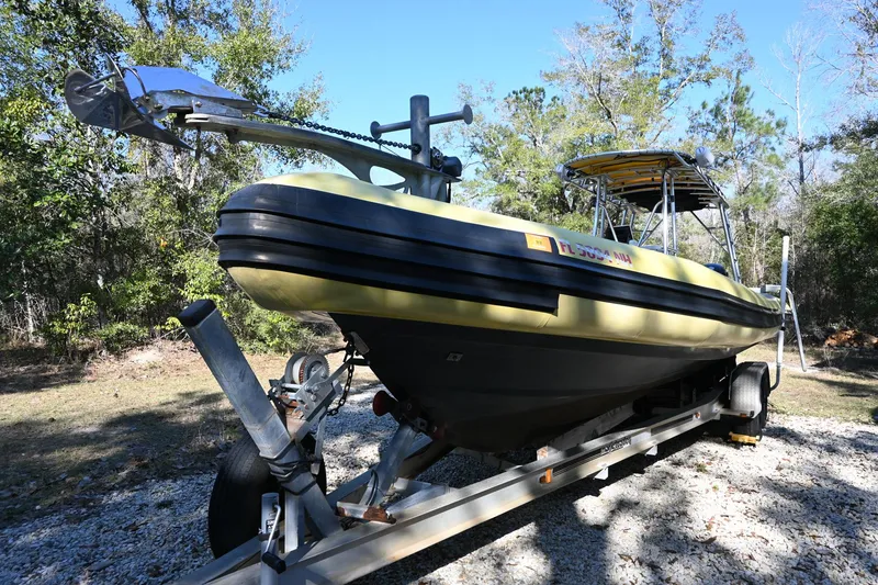 Slide: The Image of 2007 Ribcraft 9.0 boat on trailer, surrounded by trees, under clear blue sky. - 5