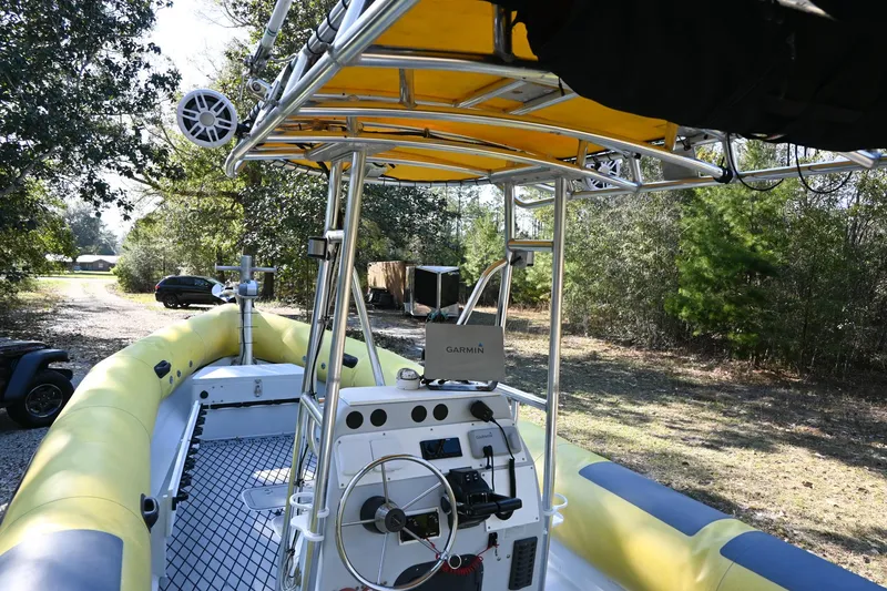 Slide: The Image of 2007 Ribcraft 9.0 boat with yellow inflatable sides and steering console, parked outdoors. - 6