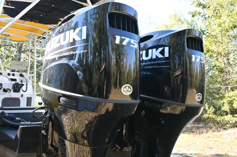 Slide: The Image of Twin Suzuki 175 outboard motors on a 2007 Ribcraft 9.0 boat, outdoors. - 7