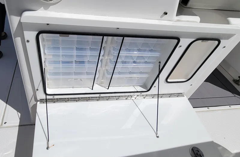 Slide: The Image of 2024 Everglades 365 Center Console tackle storage compartment with organized trays. - 16