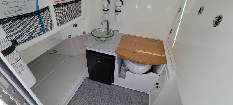 Slide: The Image of 2024 Everglades 365 Center Console interior with sink, toilet, and storage. - 19