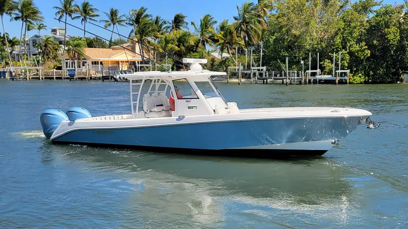 Slide: The Image of 2024 Everglades 365 Center Console boat cruising on a sunny, tropical waterway. - 23