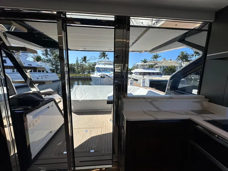 Slide: The Image of 2023 Sunseeker 65 Sport Yacht interior view with marina backdrop. - 11