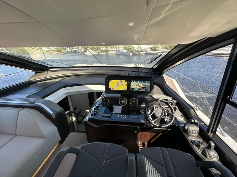 Slide: The Image of 2023 Sunseeker 65 Sport Yacht helm with modern navigation system and luxurious interior. - 13