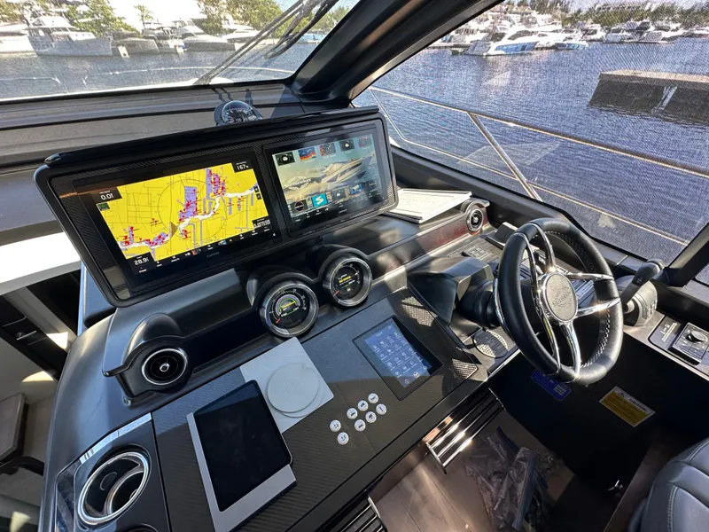 Slide: The Image of Helm of 2023 Sunseeker 65 Sport Yacht with advanced navigation displays and controls. - 14