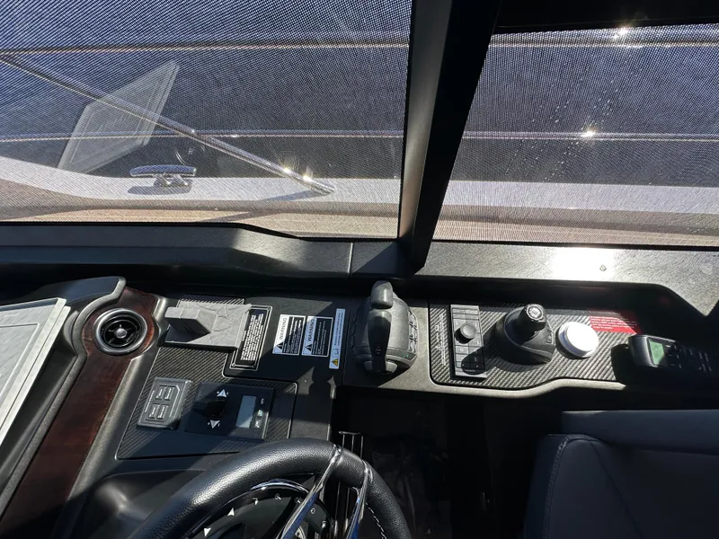 Slide: The Image of 2023 Sunseeker 65 Sport Yacht helm with controls and steering wheel. - 15