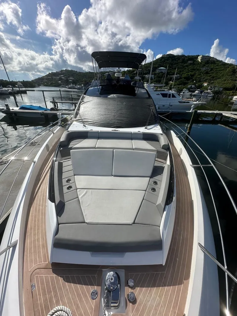 Slide: The Image of 2023 Sunseeker 65 Sport Yacht docked, showcasing sleek design and luxurious sunbathing area. - 19