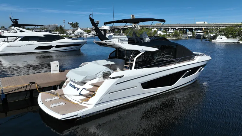 Slide: The Image of 2023 Sunseeker 65 Sport Yacht docked in a marina, showcasing sleek design and luxury features. - 2