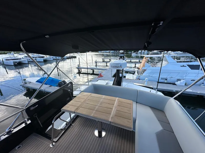 Slide: The Image of 2023 Sunseeker 65 Sport Yacht deck with seating and table, docked at marina. - 20
