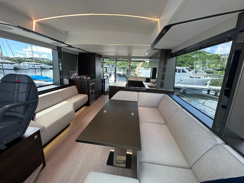 Slide: The Image of Interior of 2023 Sunseeker 65 Sport Yacht, featuring modern seating and large windows. - 27