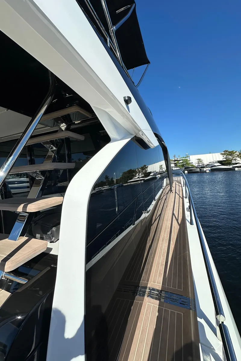Slide: The Image of 2023 Sunseeker 65 Sport Yacht, sleek design, docked by the water under a clear blue sky. - 43