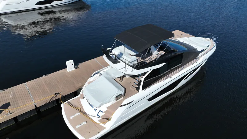 Slide: The Image of 2023 Sunseeker 65 Sport Yacht docked on calm water. - 7