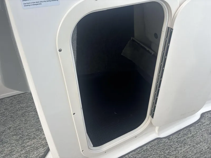 Slide: The Image of Open storage compartment on 2017 Chaparral 203 Vortex boat, featuring carpeted interior. - 14