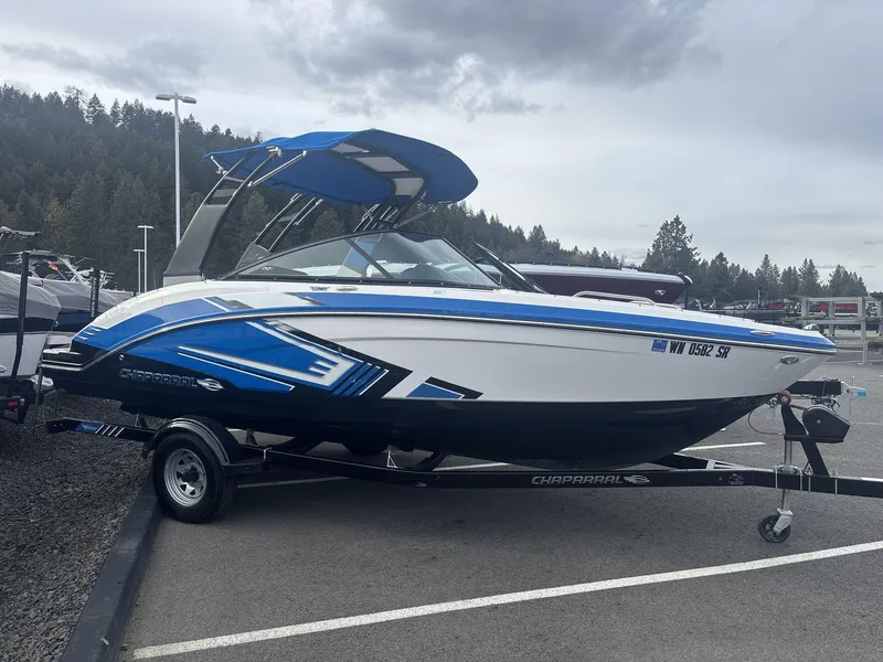 Slide: The Image of 2017 Chaparral 203 Vortex boat on trailer, parked outdoors, with blue and white design. - 3