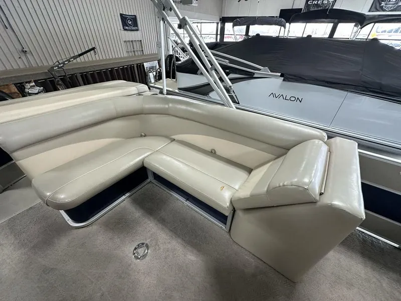 Slide: The Image of 2013 Crest II 210 Series boat interior with beige seating in a showroom. - 10
