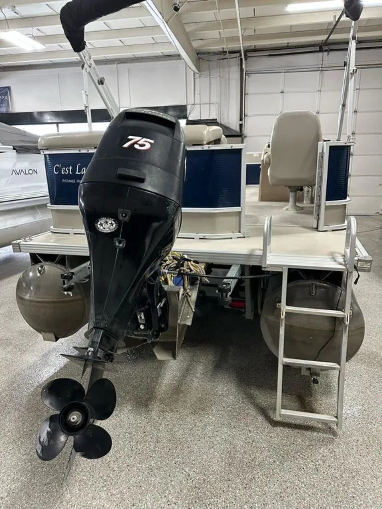 Slide: The Image of 2013 Crest II 210 Series pontoon boat with 75 HP outboard motor in a garage. - 13