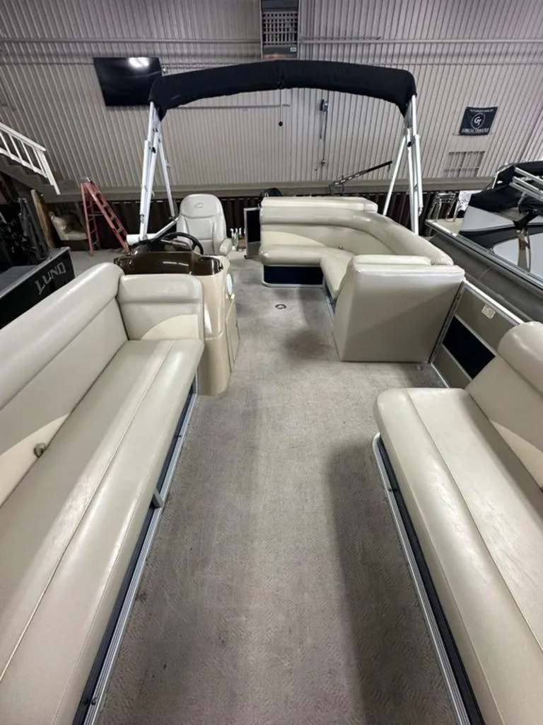 Slide: The Image of 2013 Crest II 210 Series pontoon boat interior with beige seating and canopy. - 6