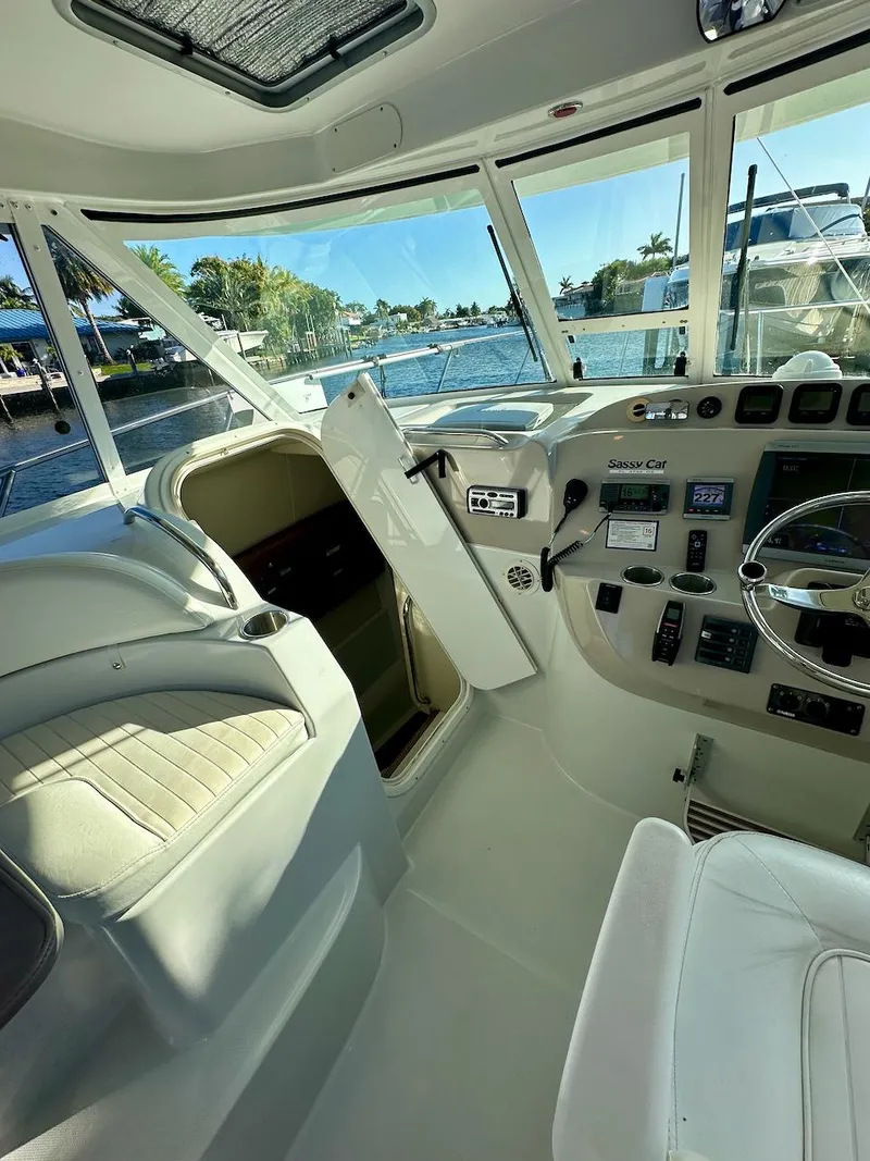 Slide: The Image of 2009 Glacier Bay 3080 boat interior with steering wheel and seating, docked by the water. - 4