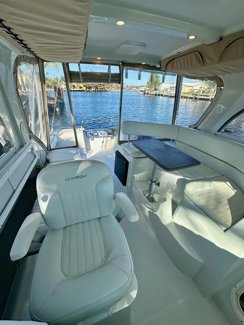 Slide: The Image of Interior of a 2009 Glacier Bay 3080 boat with white seating and waterfront view. - 8