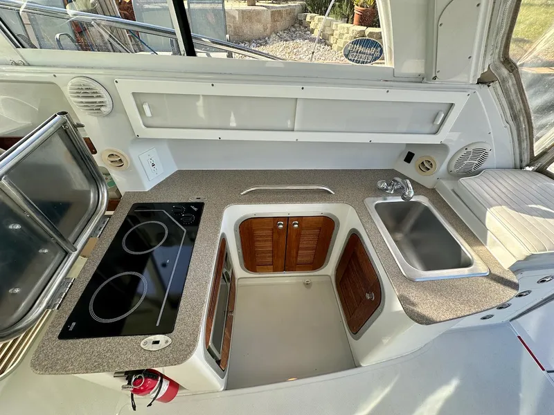Slide: The Image of Compact kitchen area in a 2009 Glacier Bay 3080 boat with stove and sink. - 11