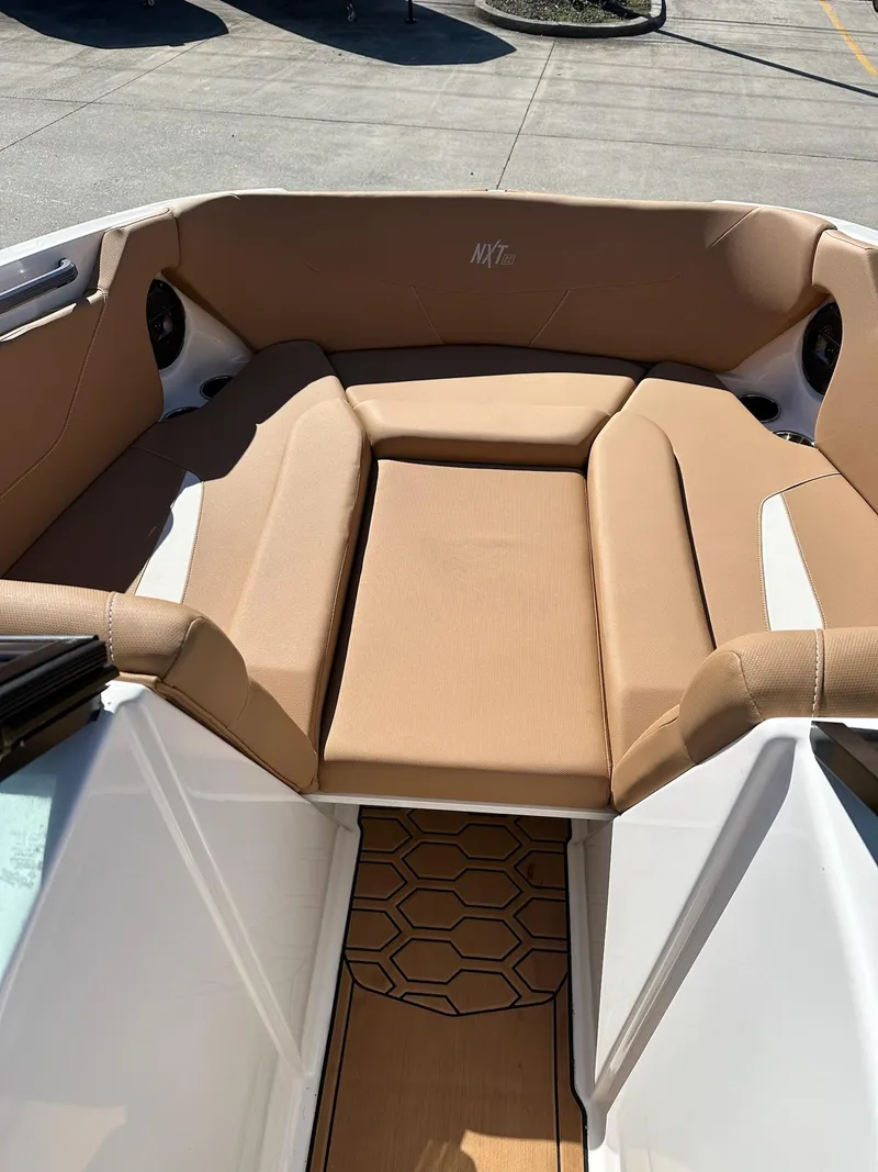 Slide: The Image of 2021 MasterCraft NXT22 boat interior with tan seating and hexagonal floor design. - 6