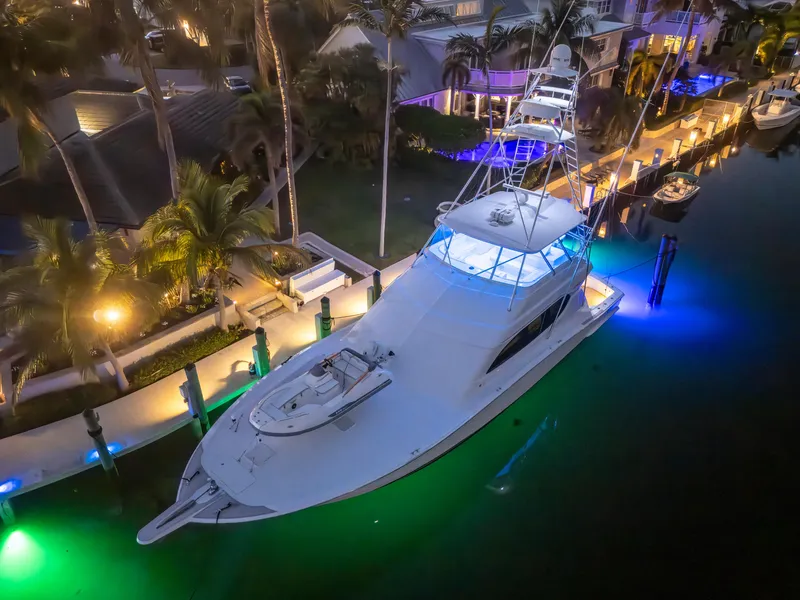 Slide: The Image of 2008 Hatteras 68 Convertible yacht illuminated at night in a marina setting. - 17