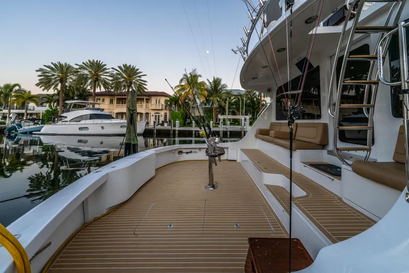 Slide: The Image of 2008 Hatteras 68 Convertible yacht docked, featuring spacious deck and luxurious seating. - 29