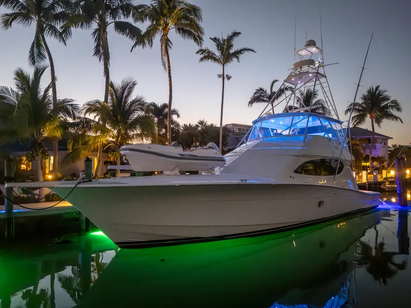 Slide: The Image of 2008 Hatteras 68 Convertible yacht docked at sunset with vibrant lighting. - 18