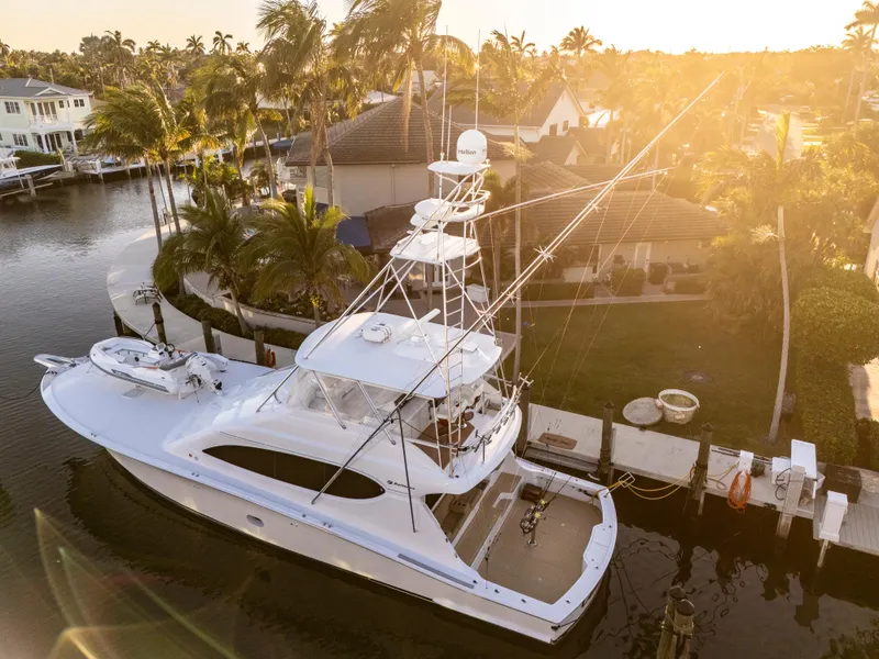 Slide: The Image of 2008 Hatteras 68 Convertible yacht docked at sunset near waterfront homes. - 4