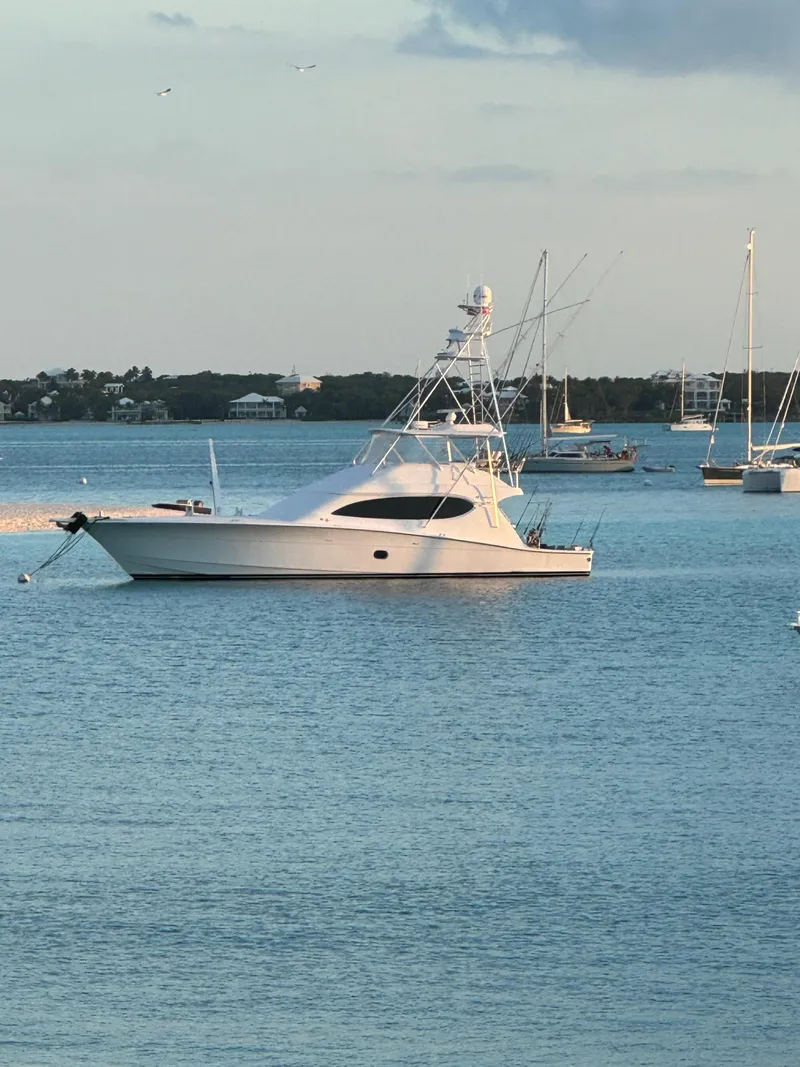 Slide: The Image of 2008 Hatteras 68 Convertible yacht anchored in calm waters. - 82