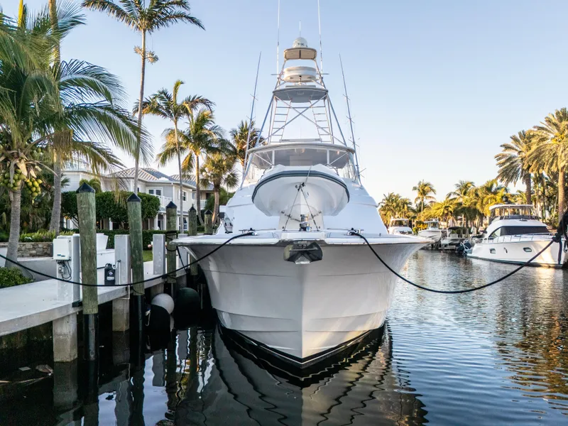 Slide: The Image of 2008 Hatteras 68 Convertible yacht docked in a tropical marina with palm trees. - 9