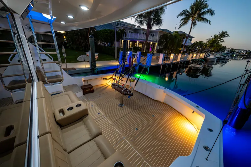 Slide: The Image of Luxurious 2008 Hatteras 68 Convertible yacht docked at sunset, featuring elegant seating and ambient lighting. - 23