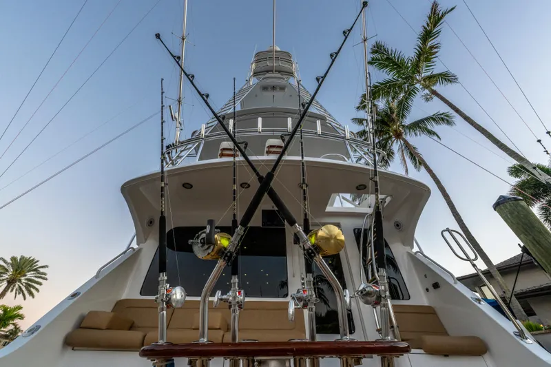 Slide: The Image of 2008 Hatteras 68 Convertible yacht with fishing rods, palm trees in background. - 26