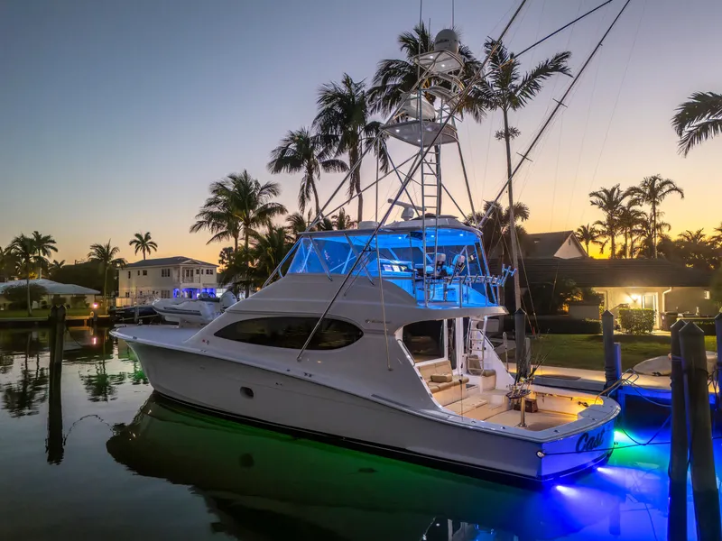 Slide: The Image of 2008 Hatteras 68 Convertible yacht docked at sunset with vibrant blue lighting. - 3