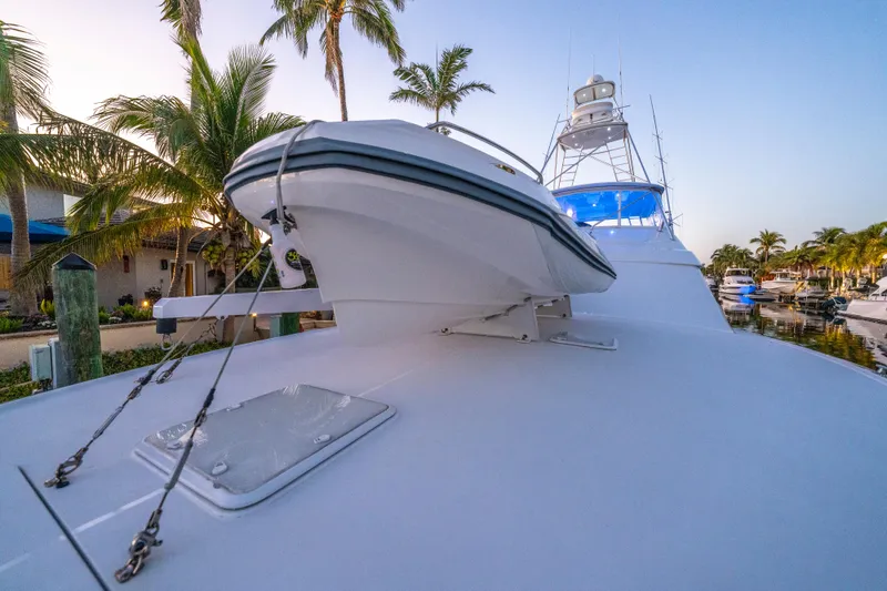 Slide: The Image of 2008 Hatteras 68 Convertible yacht docked, featuring sleek design and palm trees in the background. - 40