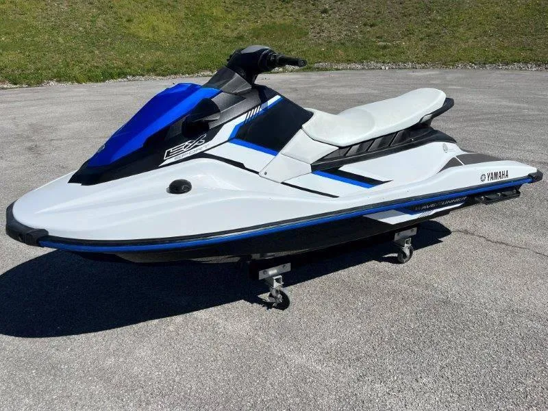 Slide: The Image of 2017 Yamaha WaveRunner EX Sport jet ski on pavement, blue and white design. - 5