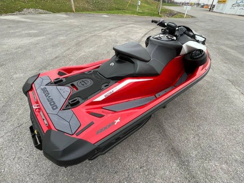 Slide: The Image of 2024 Sea-Doo RXP-X 325 Sound, red and black jet ski, parked on pavement. - 10